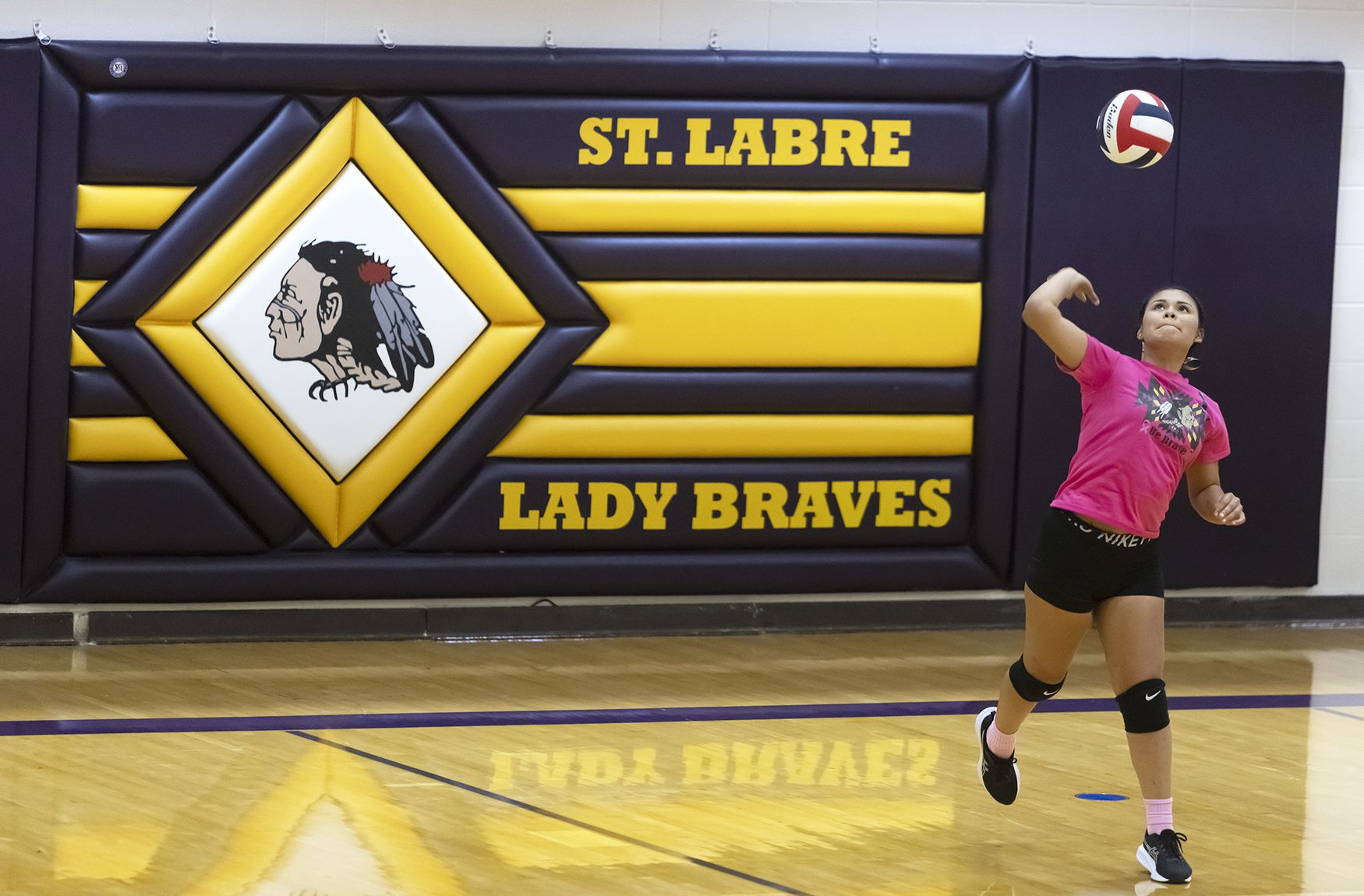 A Lady Braves player, wearing pic in honour of breast cancer awareness, serves during a match against the Lodge Grass High School Lady Indians at St. Labre Indian School on Oct. 22, 2024.