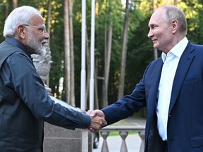 ウクライナ戦争 ロシア国営通信スプートニクが配信したプール写真で、7月8日、ノボ・オガリョヴォ公邸での非公式会談で握手するナレンドラ・モディとウラジーミル・プーチン。カメラマンセルゲイ・ボビーリョフ/AFP/Getty Images