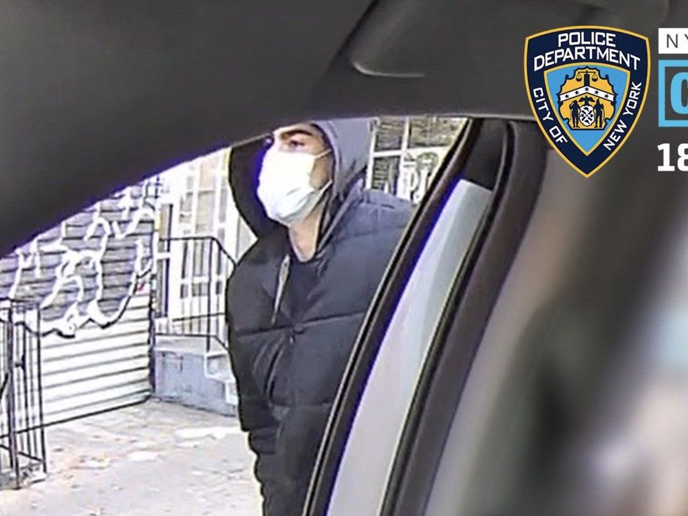 A man wearing a medical mask prepares to enter a taxi