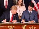 Foreign Affairs Minister Chrystia Freeland looks on as President Donald Trump looks over at Prime Minister Justin Trudeau's document during the signing of a trade agreement in Buenos Aires, Nov. 30, 2018.