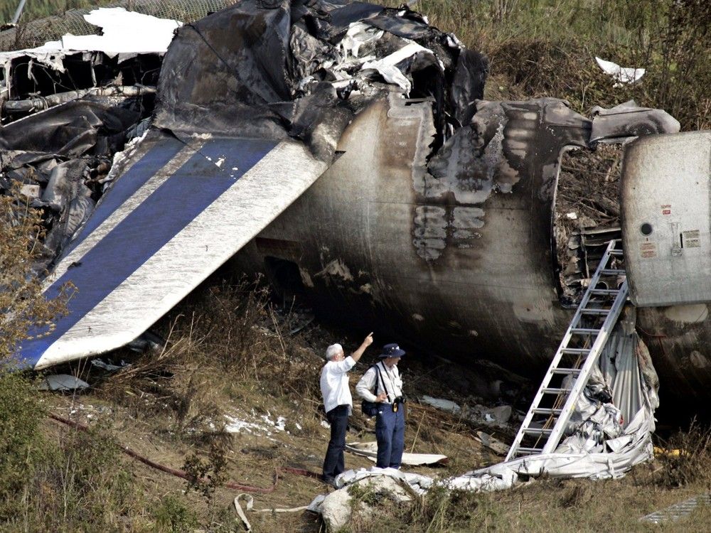 Investigators review the remains of the Air France plane which crashed on landing, at Pearson Airport in Toronto, on Aug. 3, 2005.