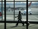 A traveller passes Air Canada planes at Pearson International Airport in Toronto, Ont.