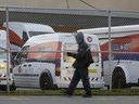 Postal worker walks past Canada Post trucks behind a fence line during the strike and lockout in Mississauga, Friday Nov. 29, 2024.