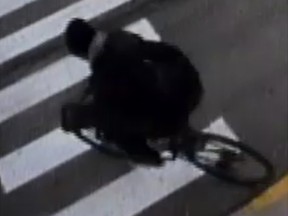 A person in dark clothes riding a bicycle.