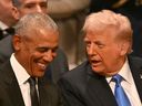 Former U.S. president Barack Obama laughs in response to something said by president-elect Donald Trump prior to Jimmy Carter's state funeral in Washington, D.C.
