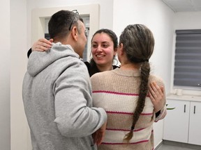 A young woman embraces her parents
