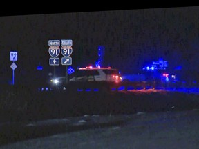 Police cars stopped on a road at night.
