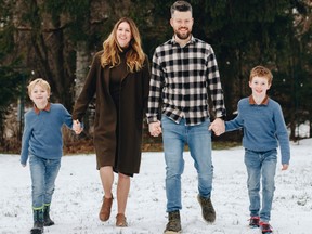 A caucasian family consisting of, from the left, a boy, his mother, his father and his younger brother, walk hand-in-hand in the snow