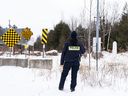 An RCMP officer looks over the border between Quebec and New York State on Roxham Road in St. Bernard-de-Lacolle, Que. on Wednesday, Jan. 15, 2025.