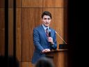 Prime Minister Justin Trudeau is pictured through glass as he speaks with members of his caucus in Ottawa, on Monday, Dec. 16, 2024.