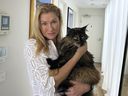 Margo Neas holds her cat Mittens at her home in Melbourne, Australia Wednesday, Jan. 22, 2025.