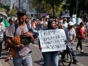A protester in Mexico City carries a sign in Spanish that says: