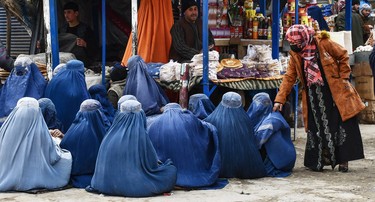 Burqa-clad women seek alms at a market in Aqcha district of Jawzjan province, Afghanistan, on February 3, 2025.