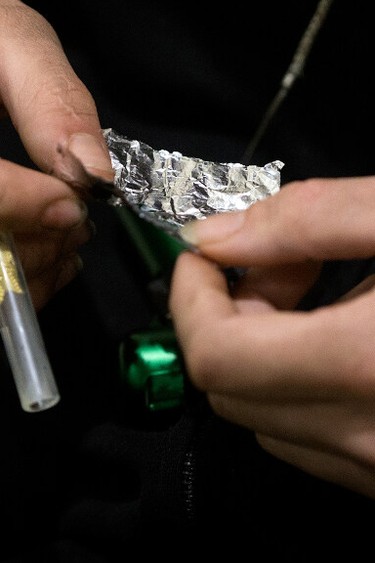 A man smokes fentanyl or carfentanil in Edmonton in this file photo from 2022.