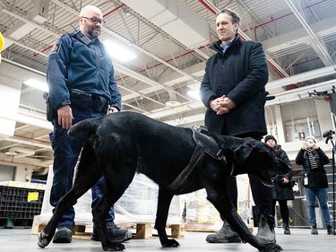 Canada's fentanyl czar Kevin Brosseau, right, is seen with Denver, a Canada Border Services Agency narcotics detection dog during a tour of the CBSA Lansdowne port of entry in Lansdowne, Ont., on Wednesday, Feb. 12, 2025.