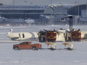 Airport firefighting vehicle surround an upside down plane on a snow-covered tarmac