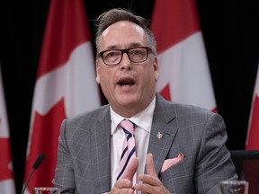 Rene Villemure talking during a press conference in front of a Canadian flag