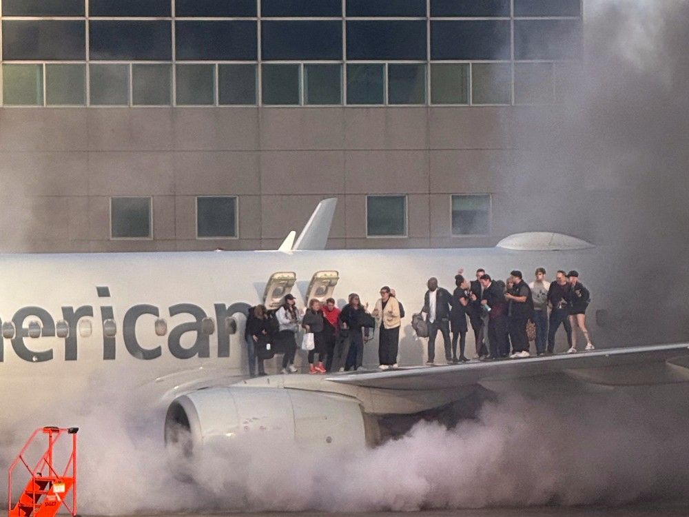 NextImg:Passengers evacuate on wing of American Airlines plane after engine bursts into flames