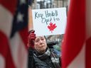 An American woman stands in Derby Line, Vermont, where people gathered outside the Haskell library to protest a new policy blocking access to the border-straddling library from the U.S. side, March 21, 2025.