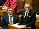 Saskatchewan Premier Scott Moe, left, listens as Finance Minister Jim Reiter delivers the 2025-26 provincial budget at the Saskatchewan Legislative Building in Regina, on Wednesday, March 19, 2025.
