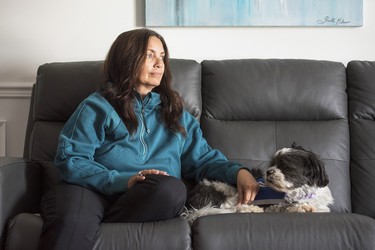 Former nurse Natasha Poirier and her service dog, Harvey, at her home in 2025.