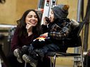 Anaida Poilievre watches her son Cruz lick the icing on his donut as they listen to their husband and father, Conservative Leader Pierre Poilievre, speak at a pre-election event, at LiUNA! Local 527's training centre in Ottawa, on Friday, March 21, 2025.