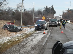 A car in a ditch as police investigate a shooting.