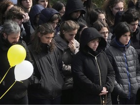 People in black pray outside