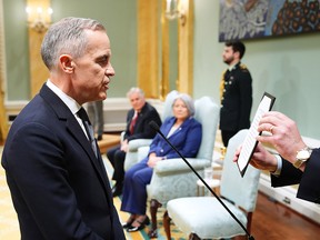Mark Carney reads an oath as he is sworn in as prime minister