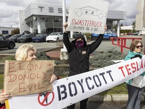 People protest outside aTesla dealership