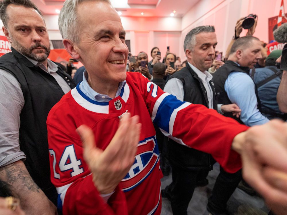 Liberal Leader Mark Carney shakes hands with supporters while wearing a Montreal Canadiens jersey.