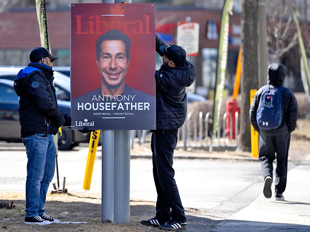  Campaign workers put up an election poster for Anthony Housefather in the Mount-Royal riding in Montreal.