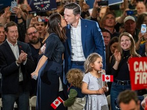 Pierre Poilievre and Anaida Poilievre kiss on stage at a campaign rally
