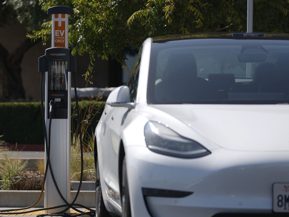 A Tesla car sits parked at an electric vehicle charging station on June 12, 2025.