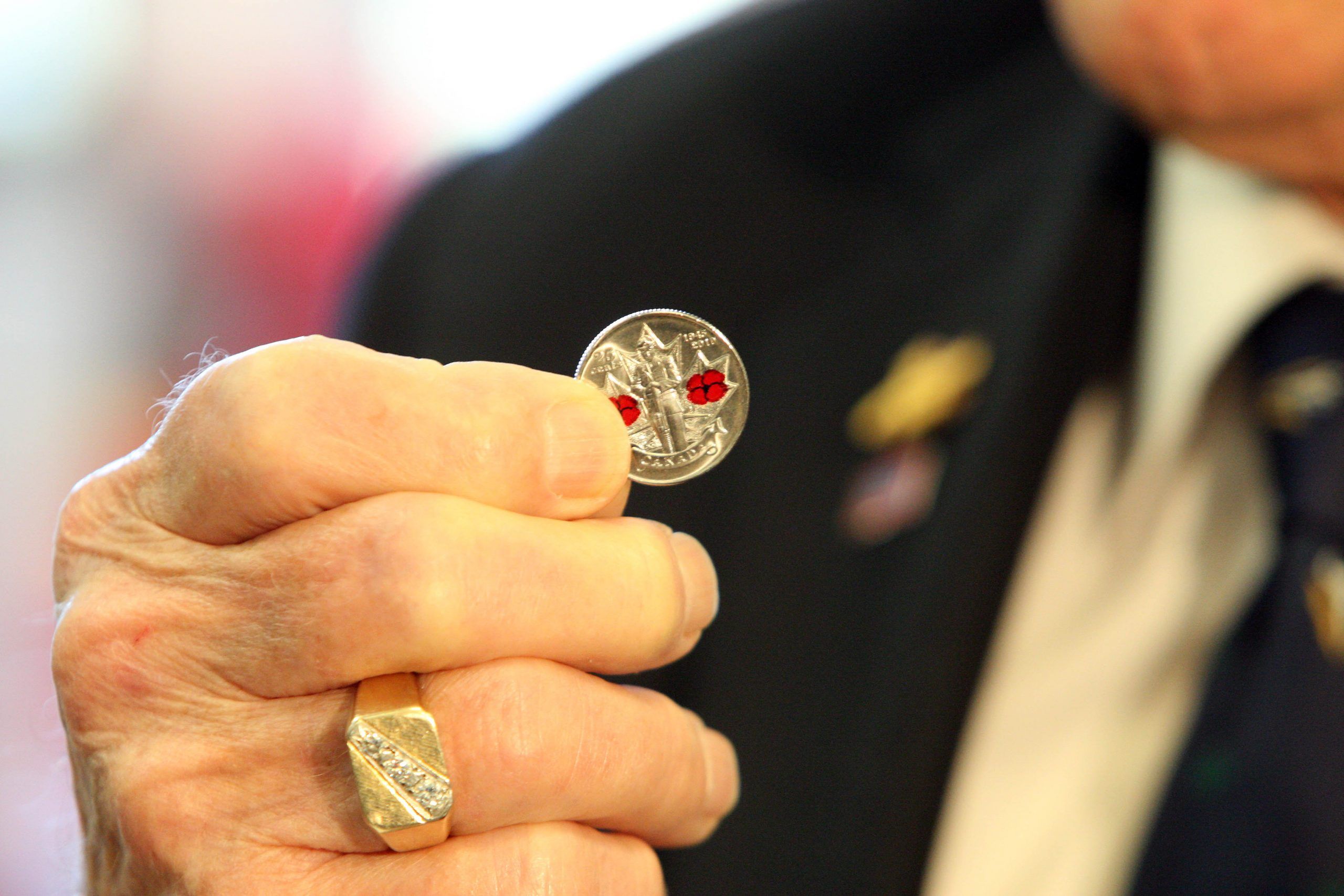  90-year-old Harold Burgis holds up a commemorative coloured quarter produced in 2010 by the Royal Canadian Mint.