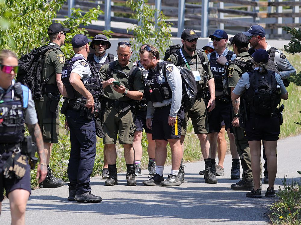  RCMP officers and Alberta Sheriffs walk on a hiking path in Kananaskis as they prepare for the G7 summit.
