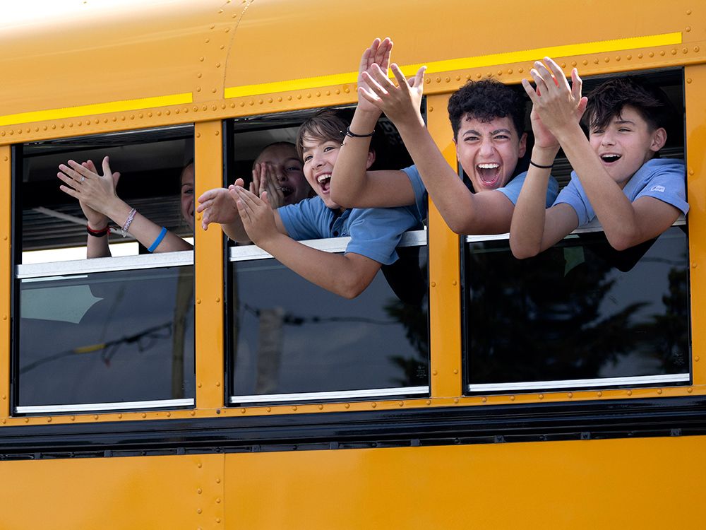  A bus of school kids cheer as they go by a police command post west of Montreal and learn toddler Claire Bell was found alive, June 18, 2025..