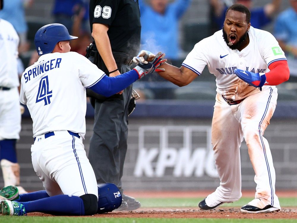 The Toronto Blue Jays' Vladimir Guerrero Jr., right, celebrates with George Springer, left, after scoring a run on a double by Bo Bichette, not pictured, during the fifth inning of a 4-1 win over the New York Yankees at Rogers Centre on Monday in Toronto.  