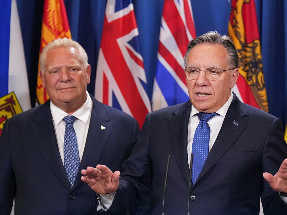 Quebec Premier François Legault, right, speaks to reporters with Ontario Premier Doug Ford during the premiers meetings in Huntsville, Ont., July 22, 2025.