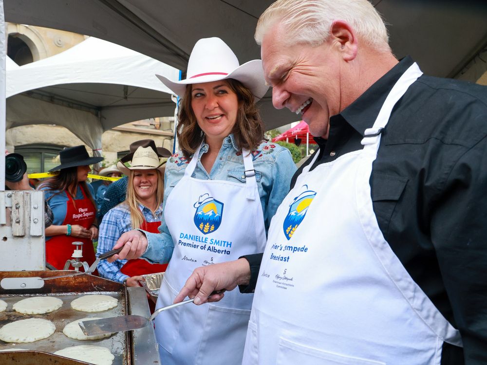  Alberta Premier Danielle Smith and Ontario Premier Doug Ford cook pancakes at the annual Premier’s Stampede Breakfast at McDougall Centre in Calgary on July 7, 2025.