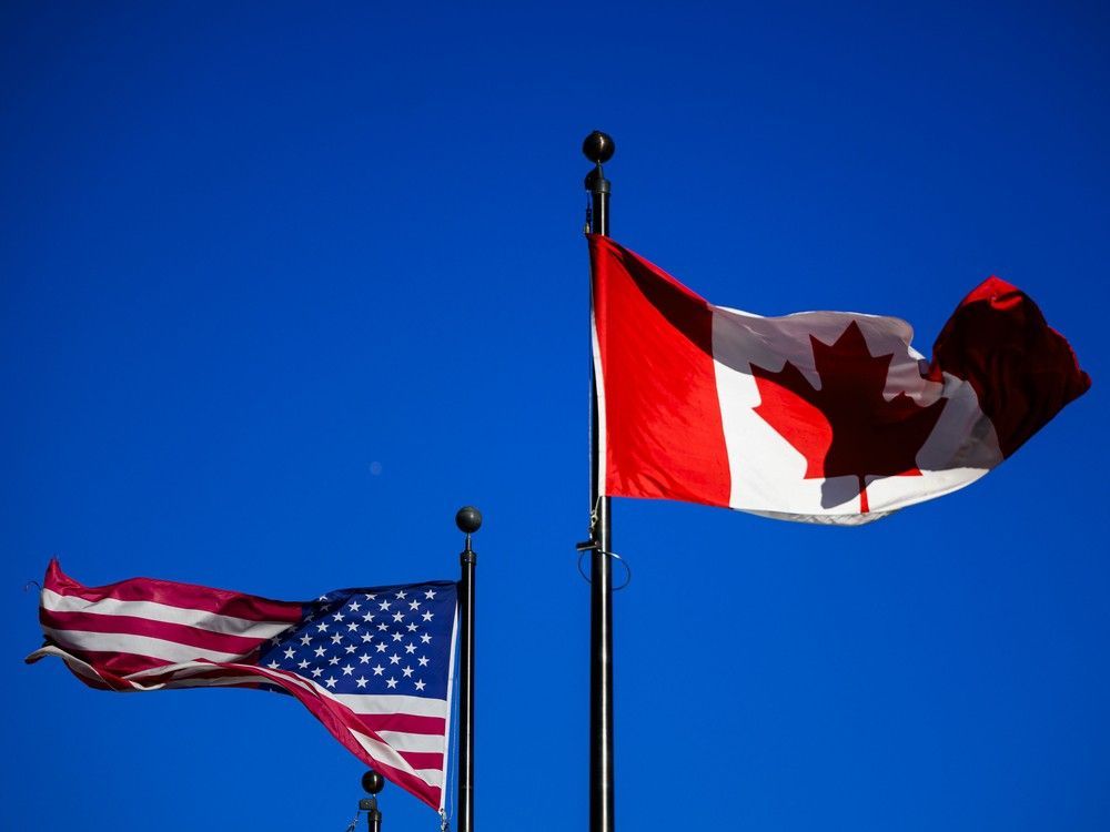 The flags of Canada and the United States fly outside a hotel in downtown Ottawa, on Saturday, Feb. 1, 2025. The flags of Canada and the United States fly outside a hotel in downtown Ottawa, on Saturday, Feb. 1, 2025.