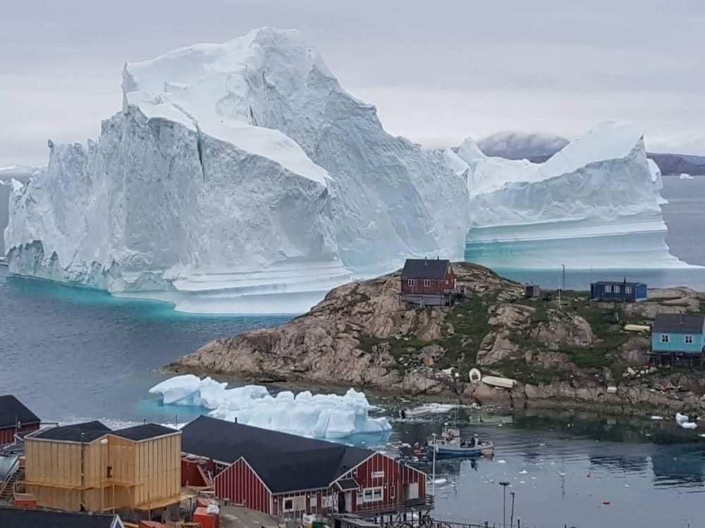 This image from July 2018 shows the last time a giant iceberg threatened the village of Innarsuit, in northwestern Greenland.