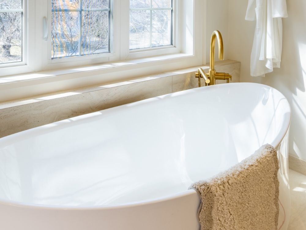 An oval tub in the primary ensuite is framed by a lighter and heated by brass luminaires. An oval tub in the primary ensuite is framed by a lighter and heated by brass luminaires.