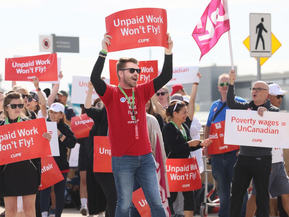 Air Canada employees walk the picket line in Calgary on Monday.