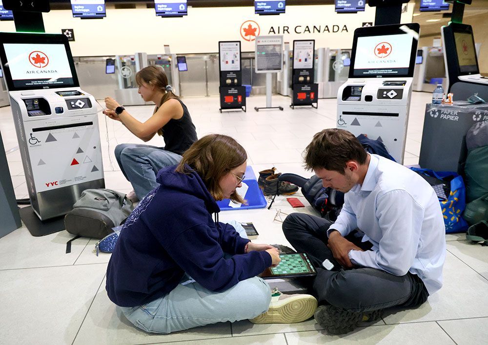 Air Canada passengers wait at the Calgary airport as the strike continues Monday.