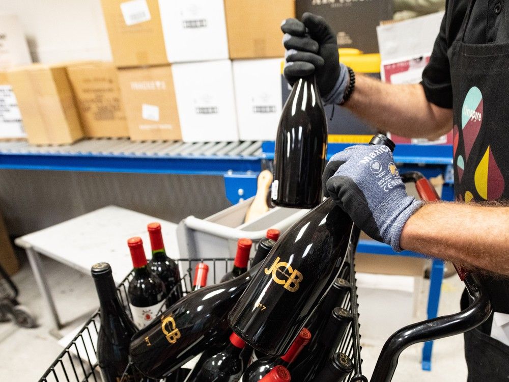  An employee removes American wines from an SAQ liquor store in Montreal on Tuesday, March 4, 2025.