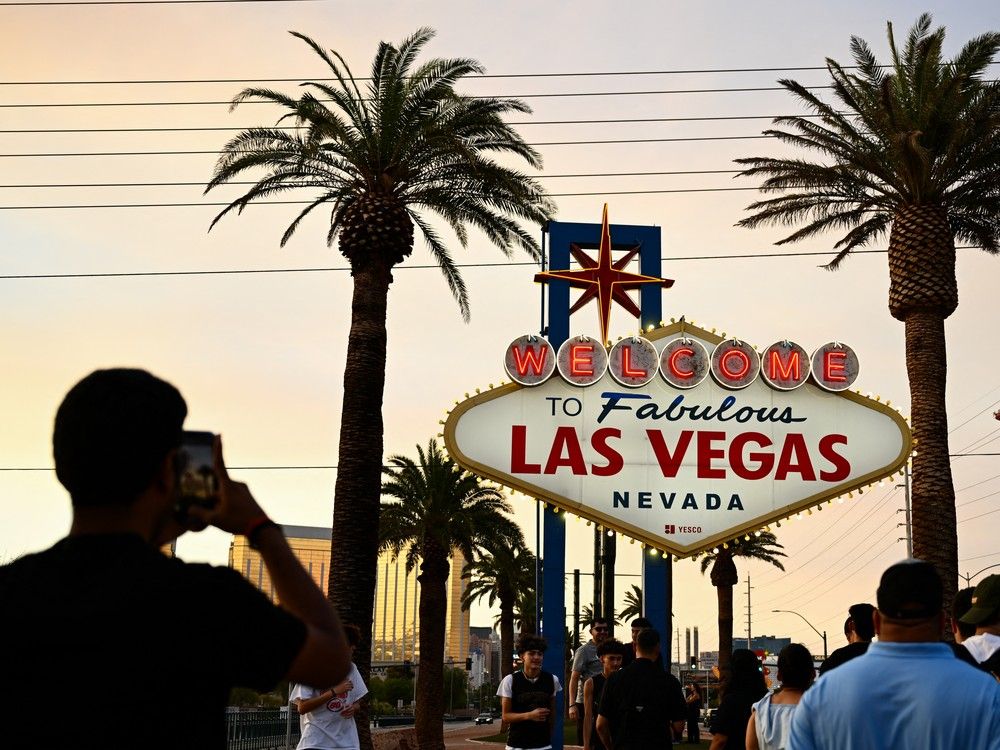  People take pictures with the Welcome To Fabulous Las Vegas sign under hazy orange skies as the sun sets in Las Vegas, Nevada.