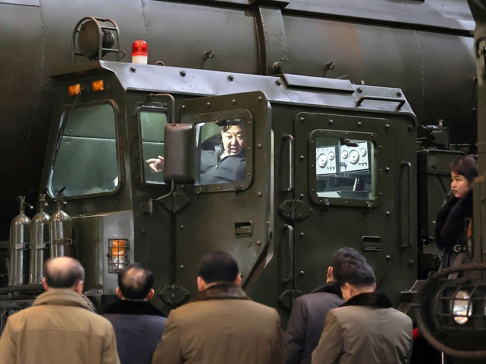  This undated picture released from North Korea’s official Korean Central News Agency (KCNA) via KNS on January 5, 2024 shows North Korea’s leader Kim Jong Un boarding a transport launcher as he inspects an important military vehicle production plant with his daughter Ju Ae.