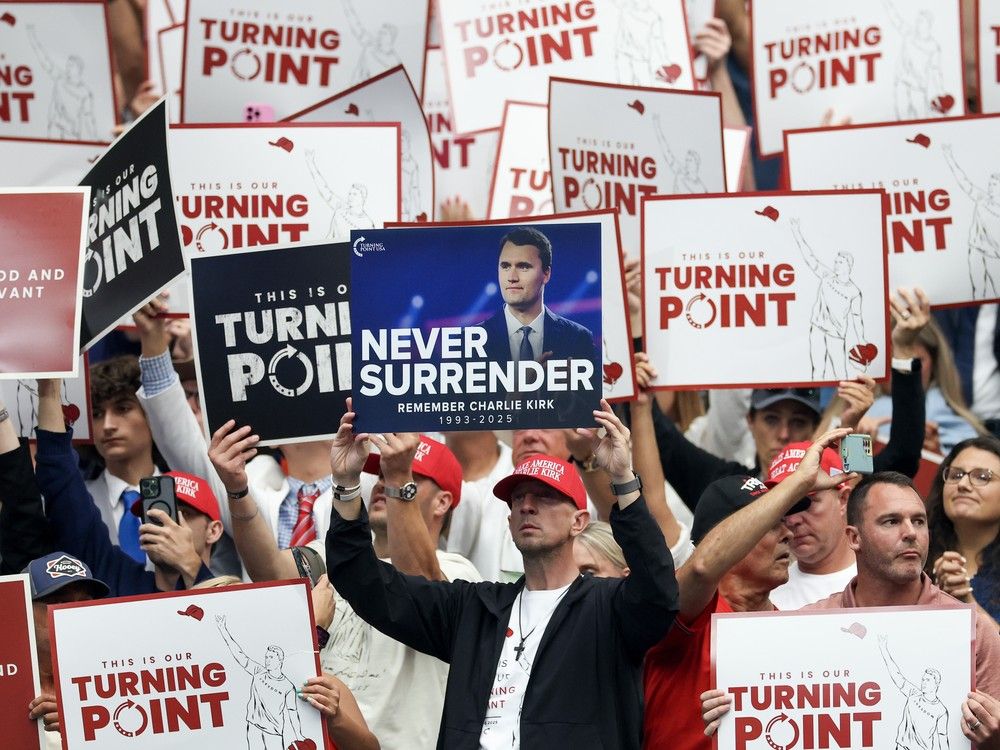 Attendees hold up signs at the memorial service for political activist Charlie Kirk at State Farm Stadium on September Sunday in Glendale, AZ.