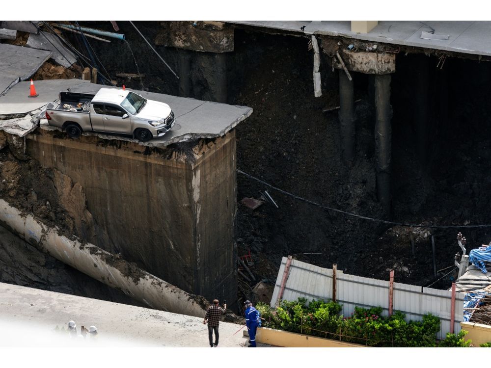 NextImg:Video shows a busy road caving, causing a massive sinkhole to open up in front of a hospital